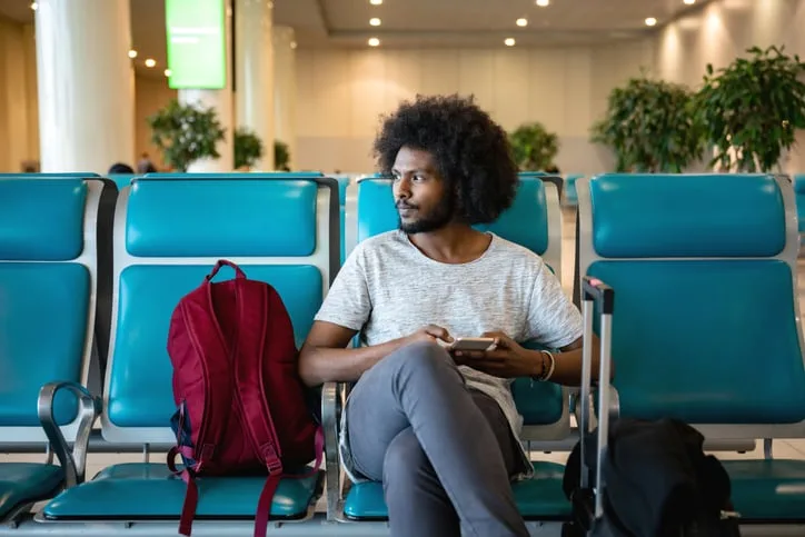 Man sitting at gate in airport.