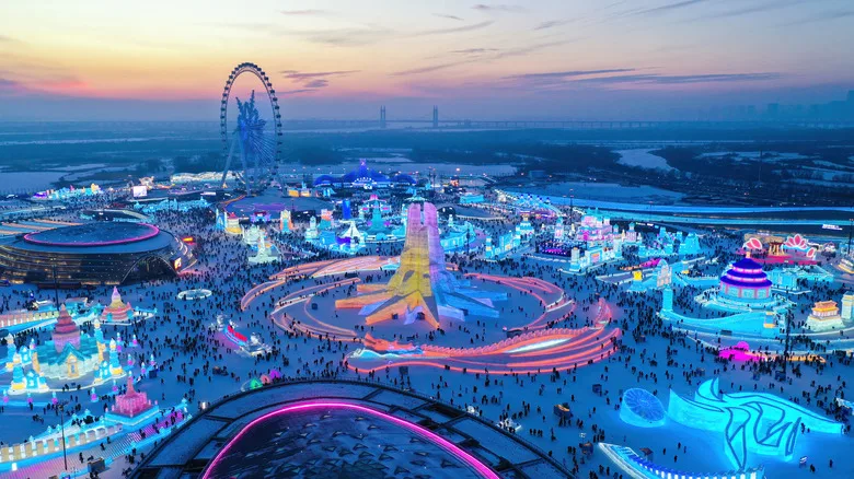 The Harbin International Ice and Snow Festival lit up as the sun sets.