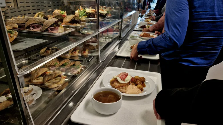 People grabbing food in cafeteria