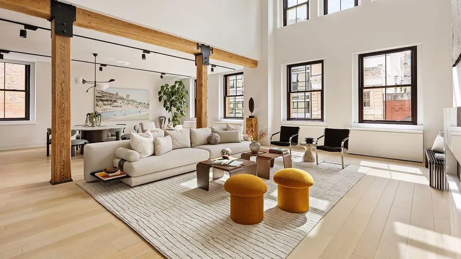 A living room with high ceilings with wooden beams.
